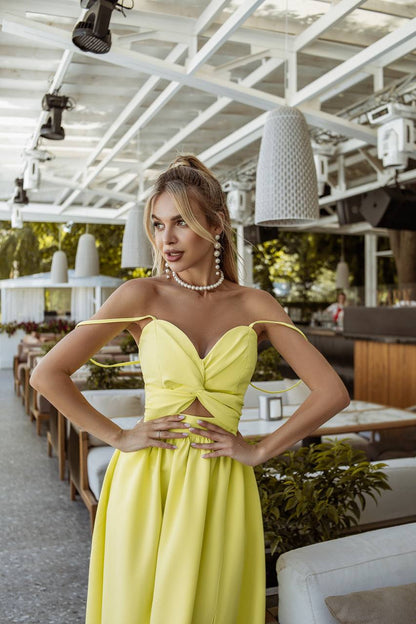 Woman in a yellow dress posing in an outdoor restaurant setting