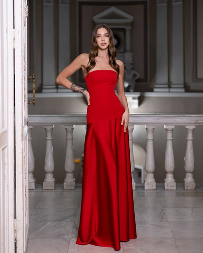 Woman in a red dress standing in an elegant interior setting