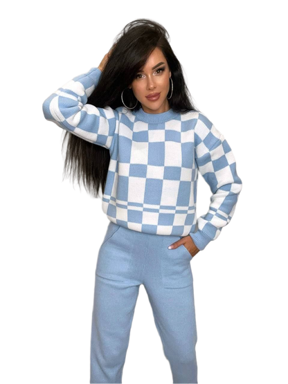 Woman wearing a blue and white checkered sweater and pants on a white background