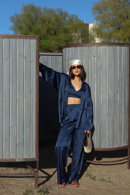 Person wearing a blue outfit standing next to metal tanks outdoors