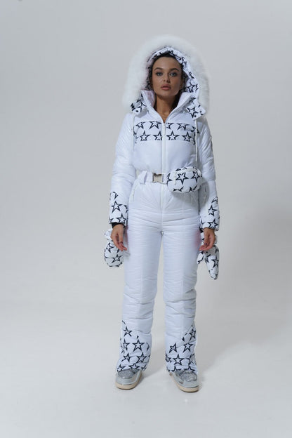 Woman wearing a white snowsuit with star patterns on a plain background