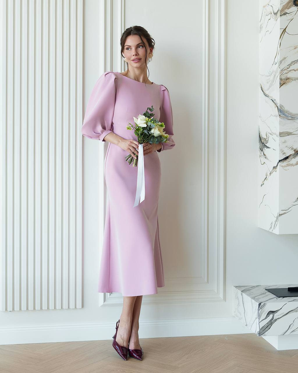 Woman in a pink dress holding flowers in an elegant interior setting