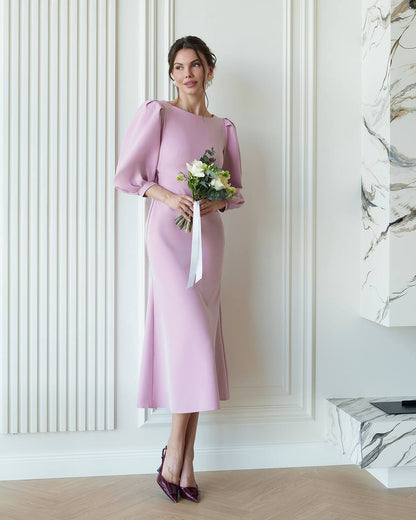 Woman in a pink dress holding flowers in an elegant interior setting