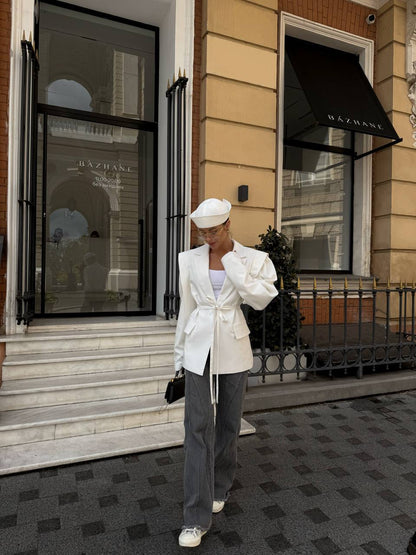 Person wearing a white outfit standing in front of a building with 'Dazhane' branding.