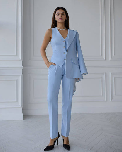 Woman wearing a light blue suit in a room with white walls.