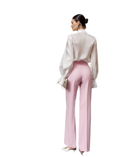 Woman wearing a white blouse and pink pants on a white background