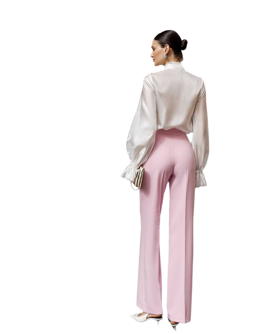 Woman wearing a white blouse and pink pants on a white background