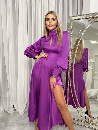Woman in a purple dress standing in front of a mirror.