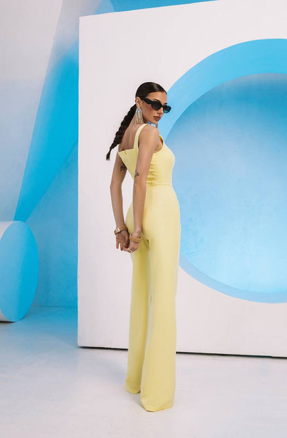 Woman in a yellow dress standing against a blue and white abstract background