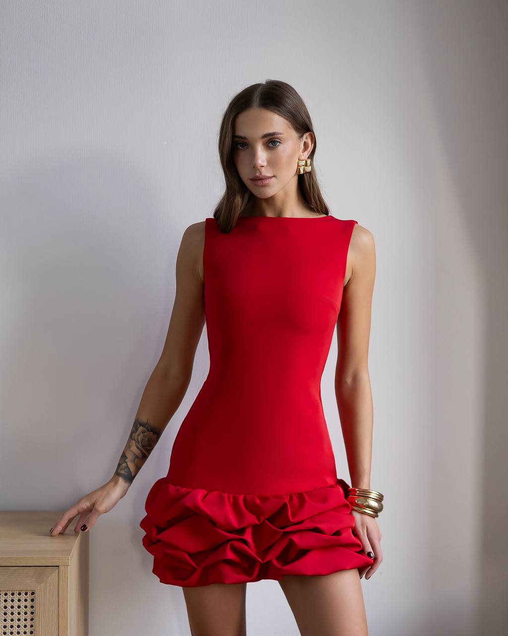 Woman wearing a red dress with ruffled skirt against a plain background