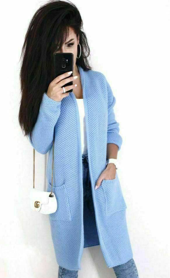 Person wearing a light blue cardigan with a white background