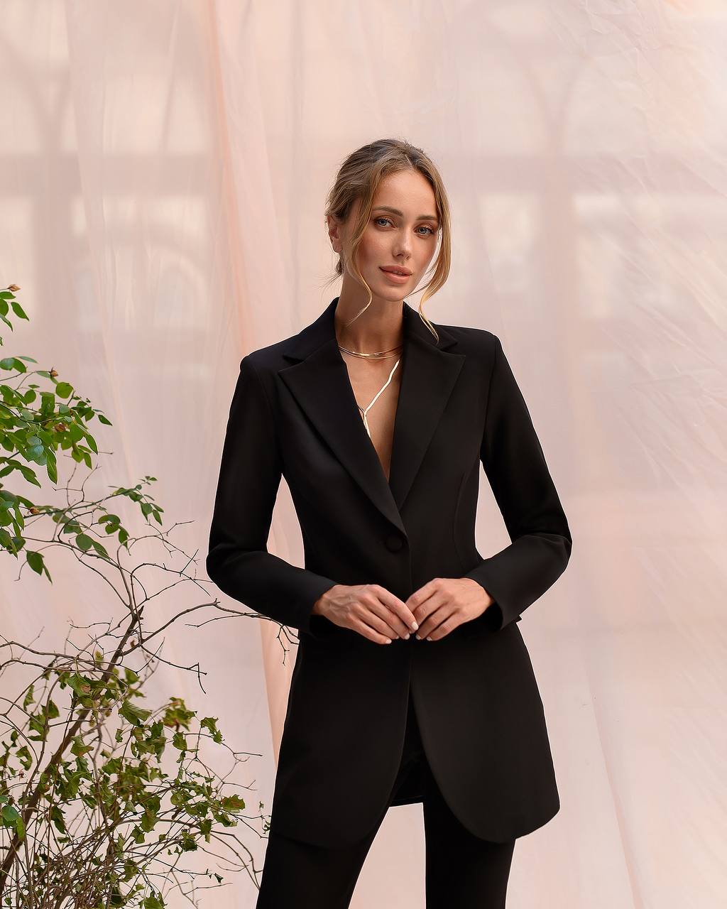 Woman wearing a black blazer against a neutral background