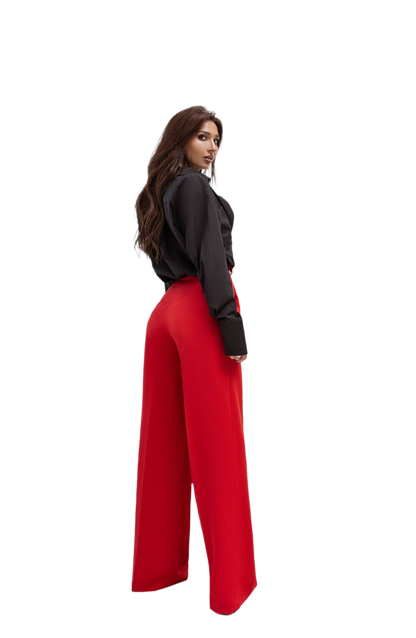 Woman wearing a black top and red pants on a white background