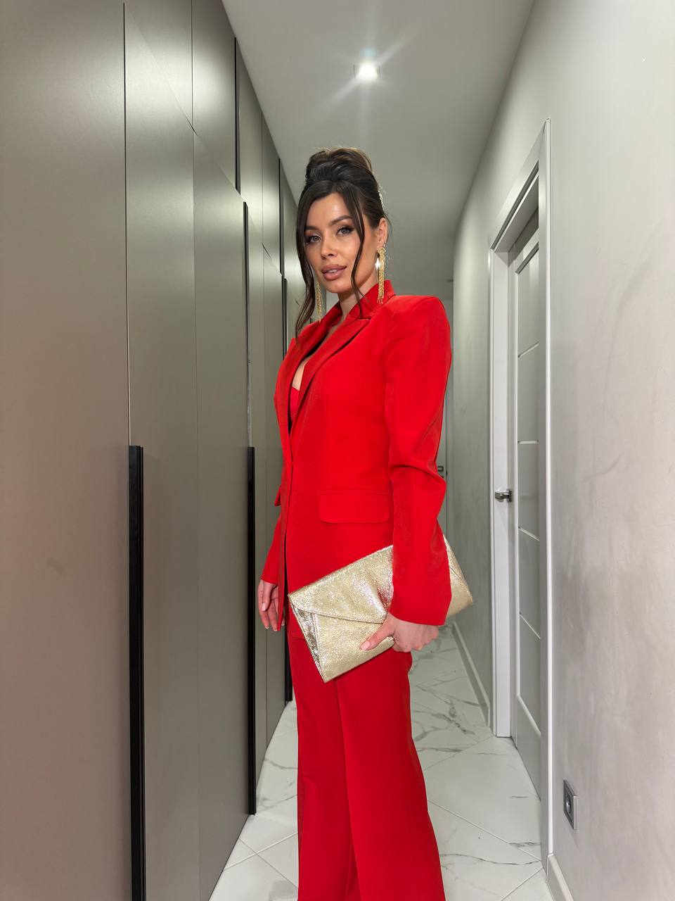 Woman in a red suit standing in a hallway
