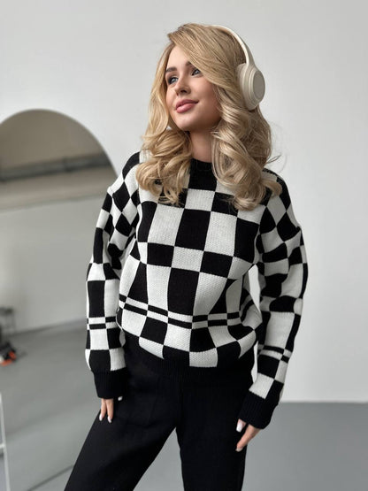 Woman wearing a black and white checkered sweater and headphones indoors.