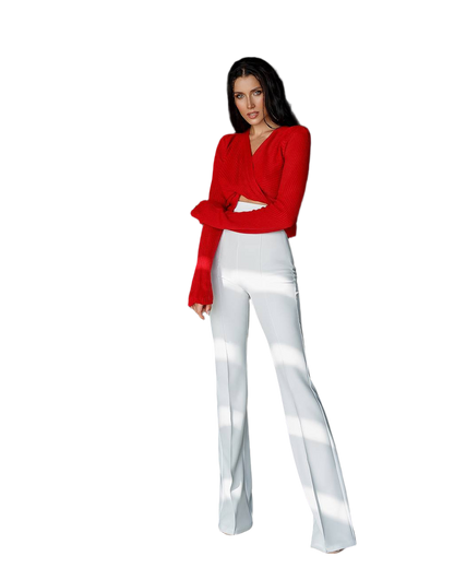 Woman wearing a red blouse and white pants on a white background