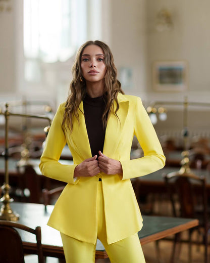 Woman wearing a bright yellow suit in an elegant indoor setting