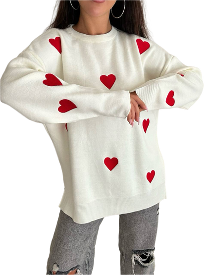 White sweater with red heart patterns worn by a person on a white background
