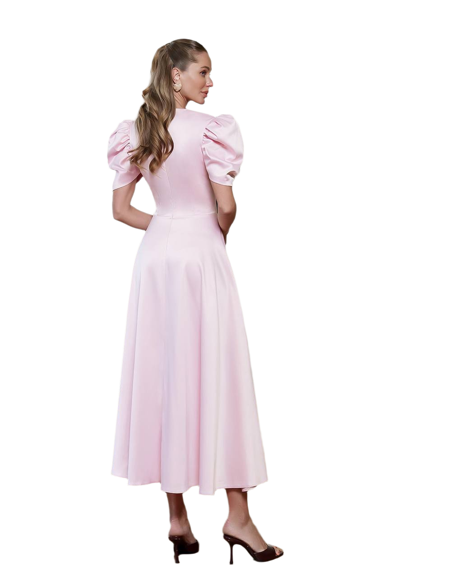 Woman wearing a pink dress with puffed sleeves on a white background