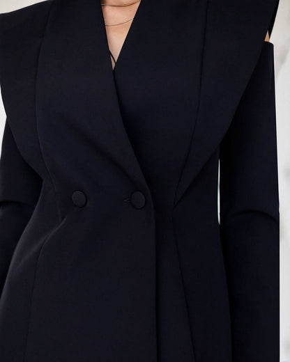 Close-up of a black blazer with a plain background