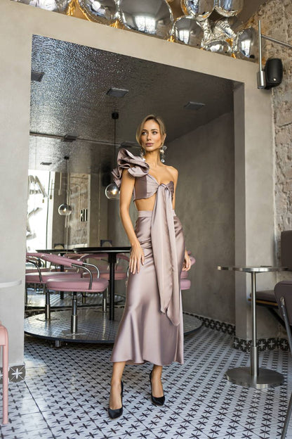 Woman in a stylish outfit standing in a modern restaurant interior.