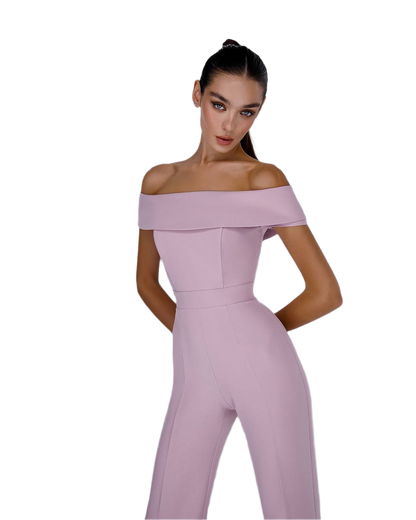 Woman wearing a pink off-shoulder jumpsuit on a white background
