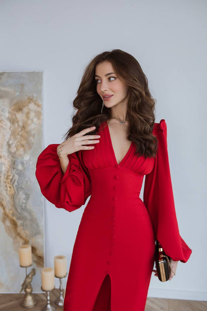 Woman in a red outfit posing indoors with a neutral background
