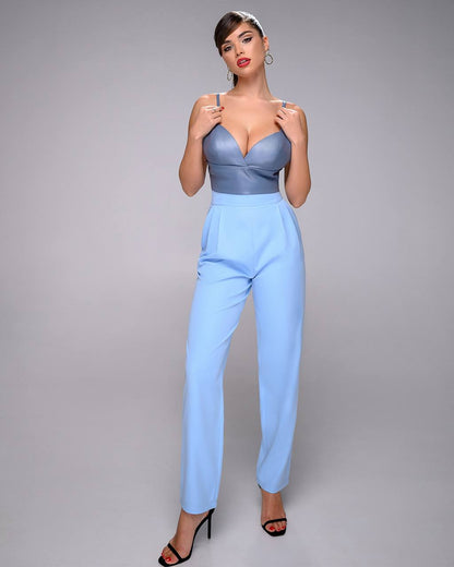 Woman wearing a blue jumpsuit against a gray background