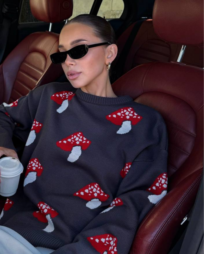 Person wearing a sweater with red and white patterns, sitting in a car.