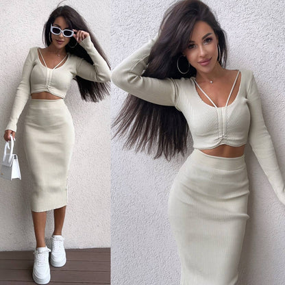 Woman wearing a white outfit with long sleeves and a skirt against a plain background