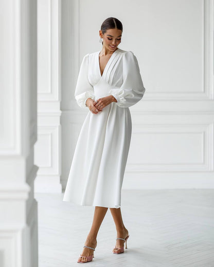Woman wearing a white dress in a minimalistic setting