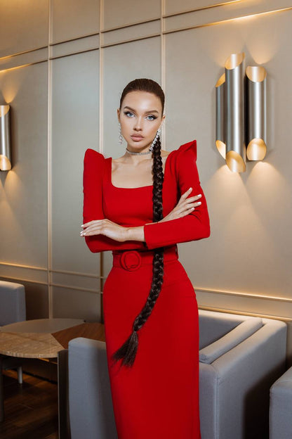 Woman in a red dress standing in an elegant interior setting