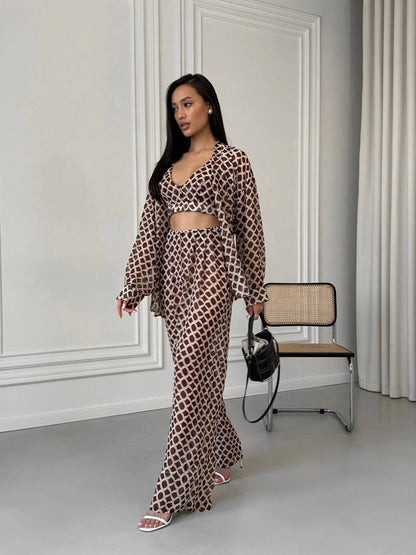Woman in a leopard print outfit standing in a room with a chair and wall.