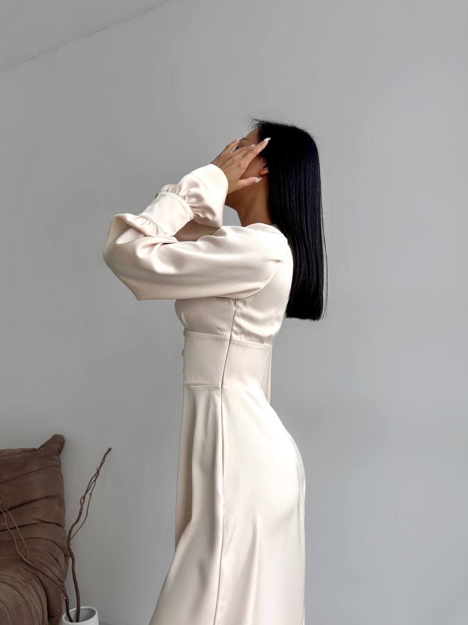 Person wearing a long white dress against a plain background