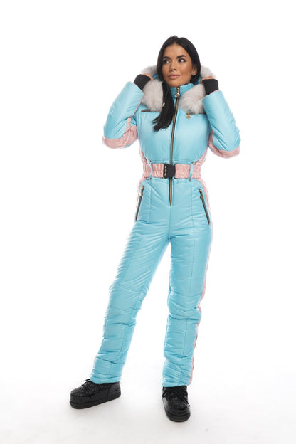 Woman wearing a light blue ski suit with pink accents on a white background