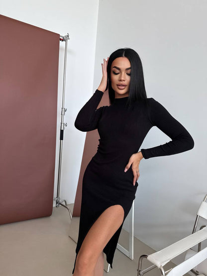 Woman in a black dress posing in a studio setting