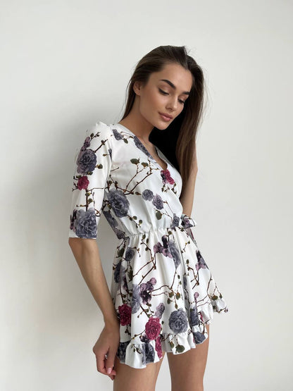 Woman wearing a floral dress against a plain background