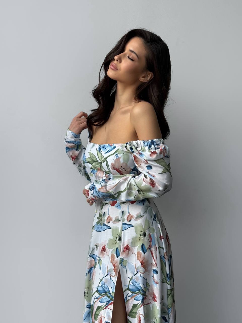 Woman wearing a floral off-shoulder dress against a gray background