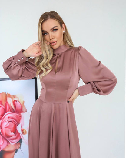 Woman wearing a pink dress with puffed sleeves against a light background