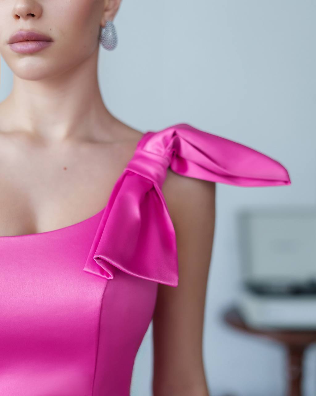 Close-up of a pink one-shoulder dress with a blurred background