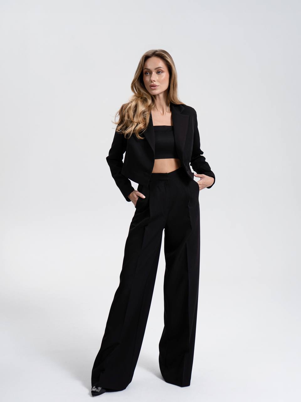 Woman wearing a black suit on a white background