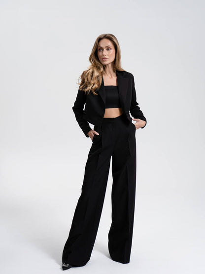 Woman wearing a black suit on a white background