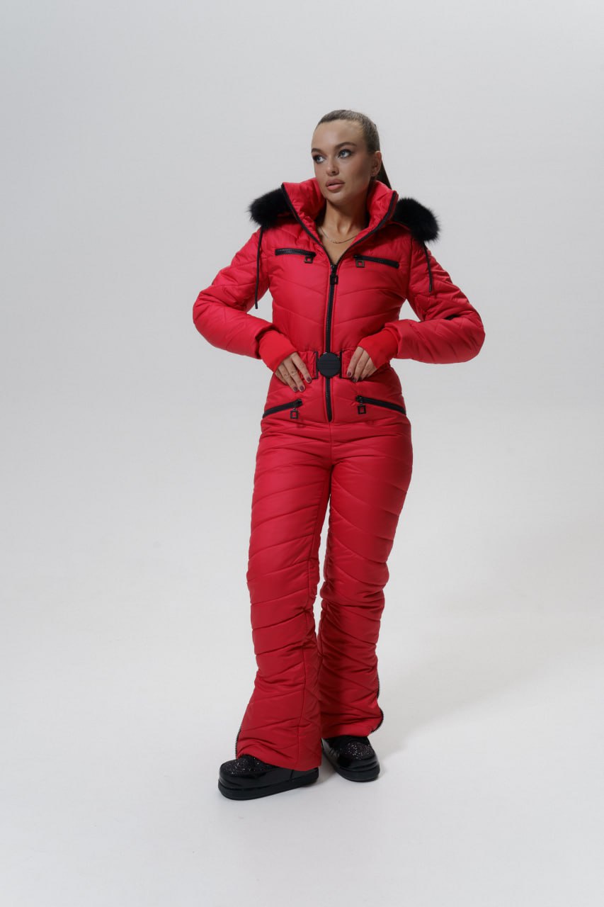 Person wearing a red snowsuit with black fur trim on a white background
