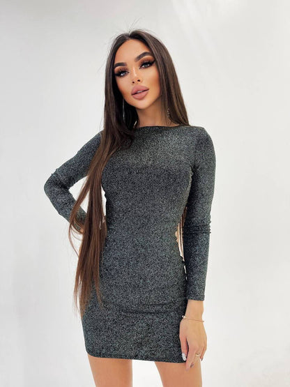 Woman wearing a gray long-sleeve dress against a white background