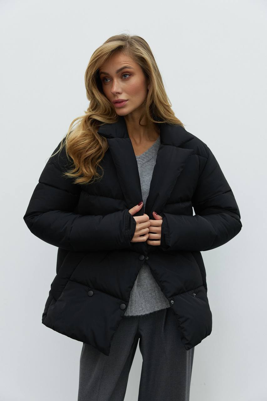 Woman wearing a black puffer jacket against a white background