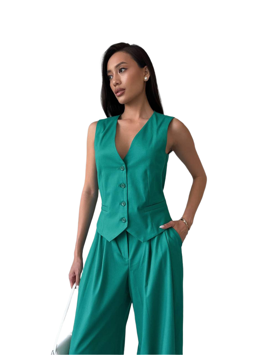 Woman wearing a teal sleeveless top and pants on a white background