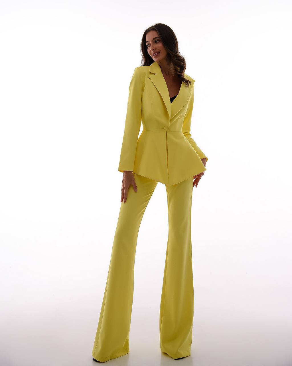 Woman wearing a bright yellow suit on a white background