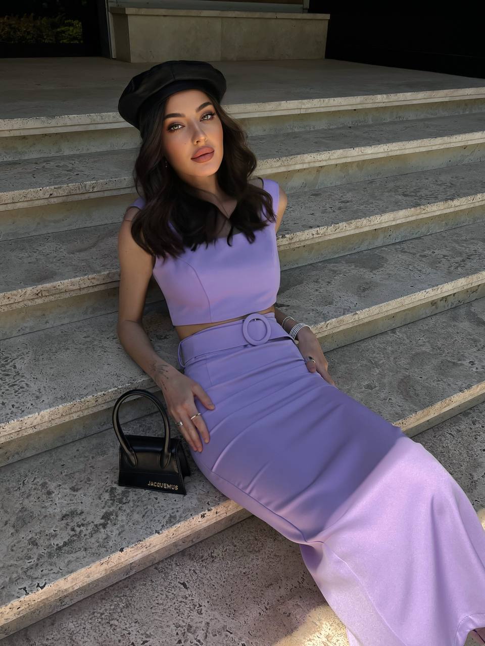 Woman in a purple outfit sitting on stone steps