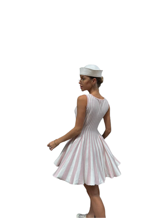 Woman wearing a white dress with red stripes and a matching hat on a white background