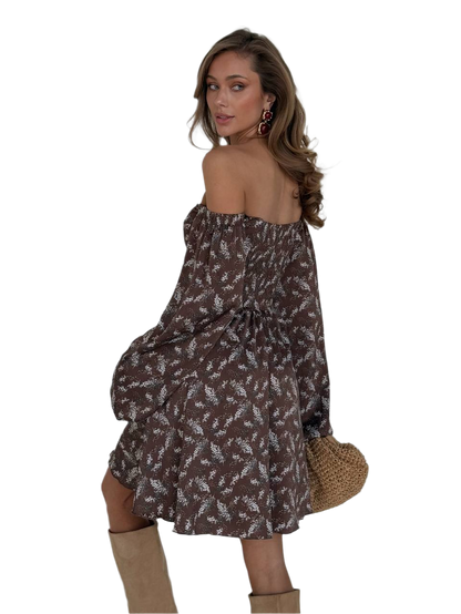 Woman wearing a floral off-shoulder dress with a white background